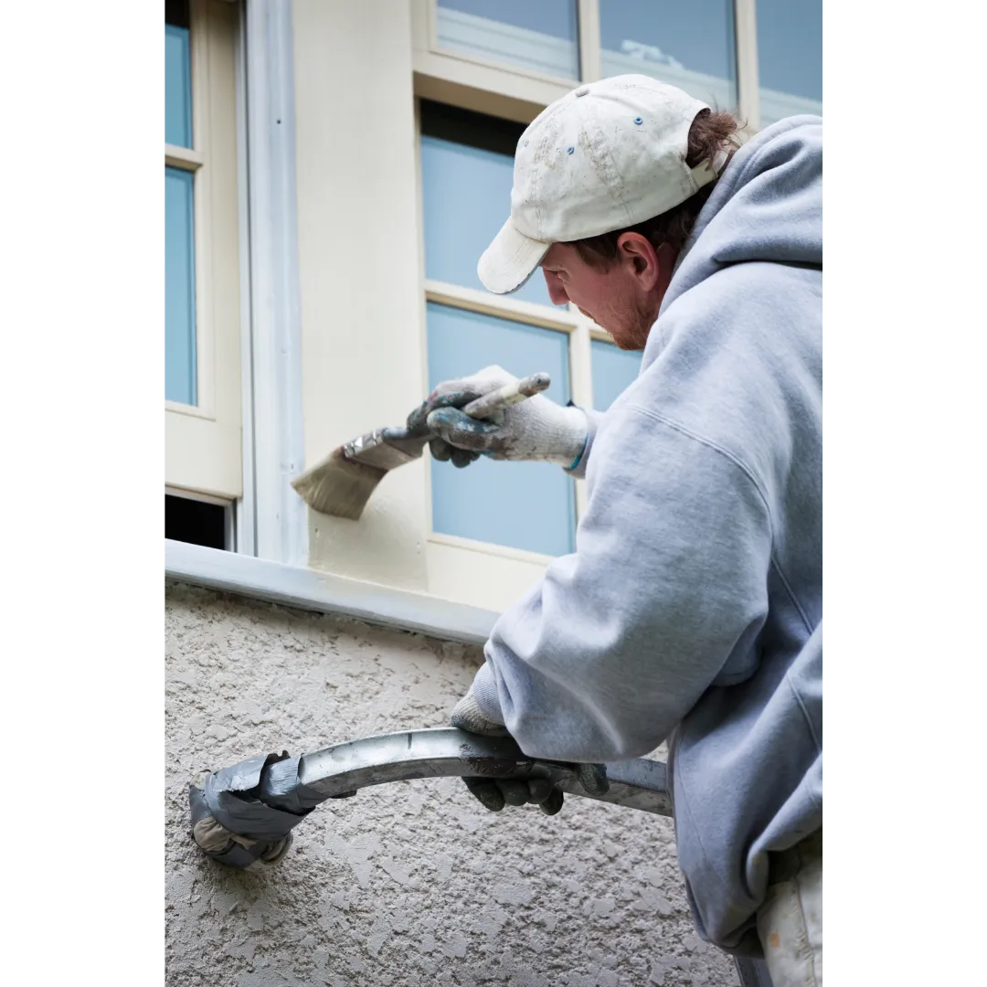 Worker painting a window frame