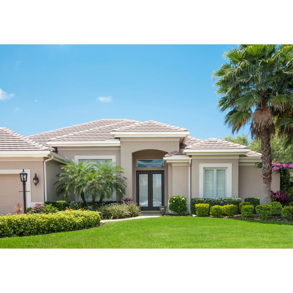 mid sized house made of stucco with a green lawn