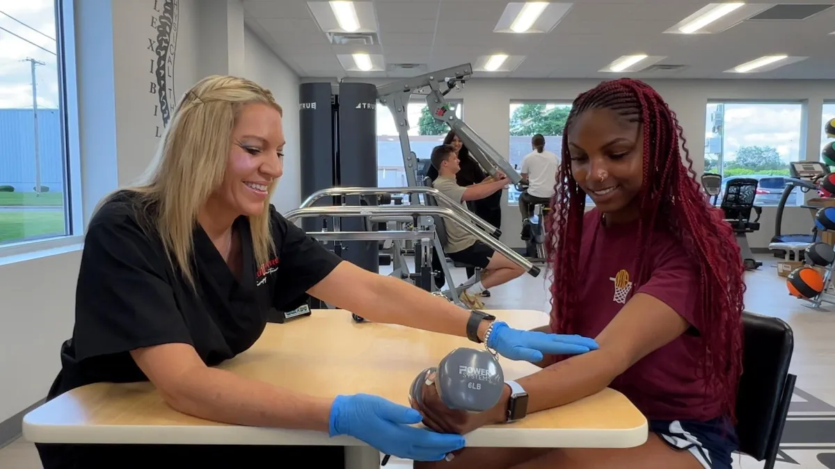 Occupational therapist guiding hand exercises at a table