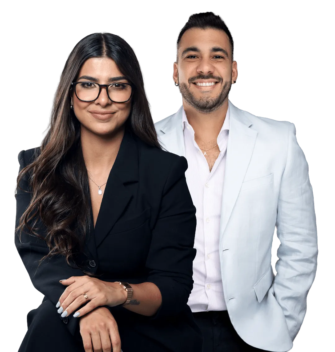 Confident bilingual broker holding vehicle keys beside a late-model sedan in a bright auction lot.