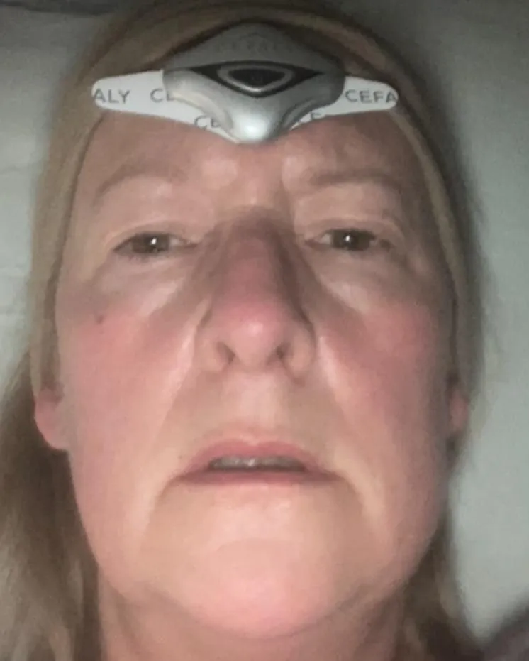 Woman resting whilst wearing migraine relief mask