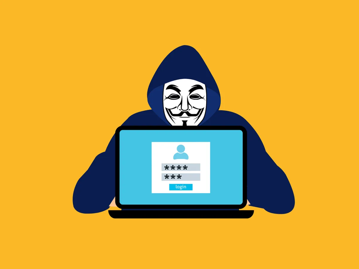 A graphic of someone in a hooded jacked and a mask hiding behind a laptop with a login screen on.