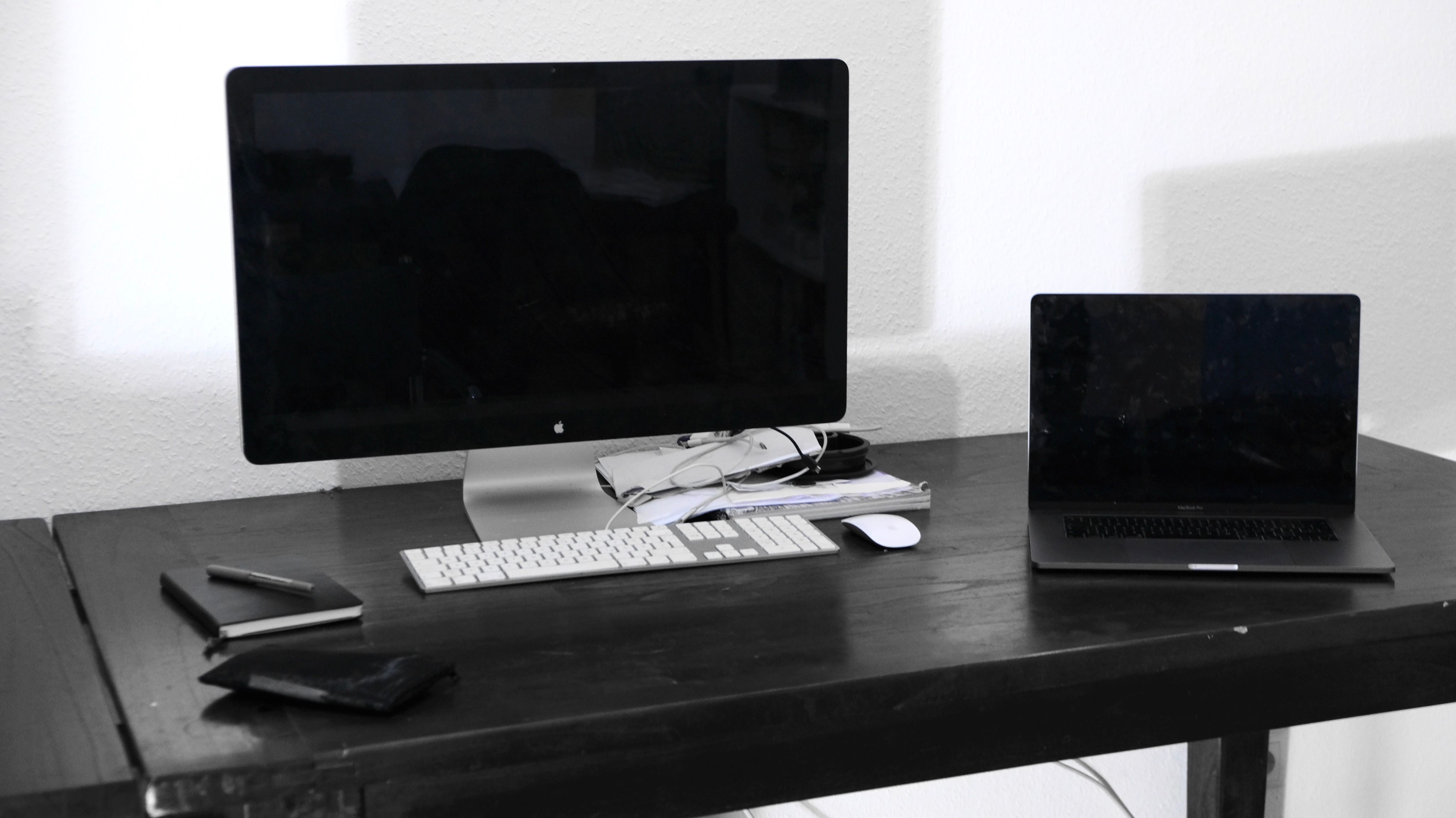 Photo of a desktop and a laptop on a table.