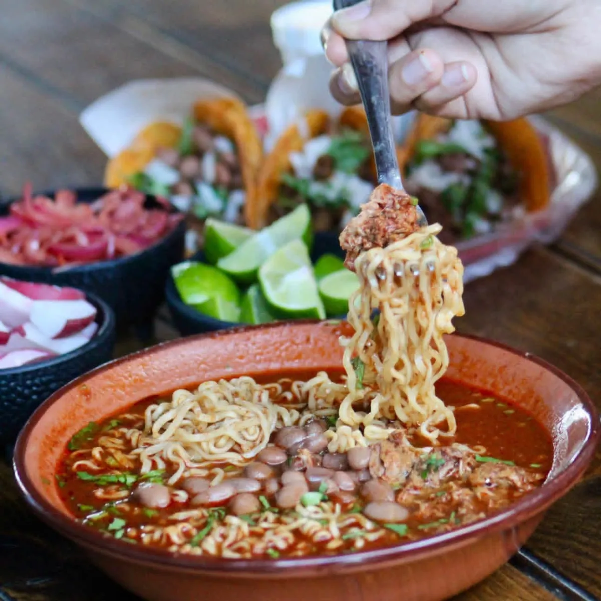 Plato de birria servida con tortillas y acompañamientos