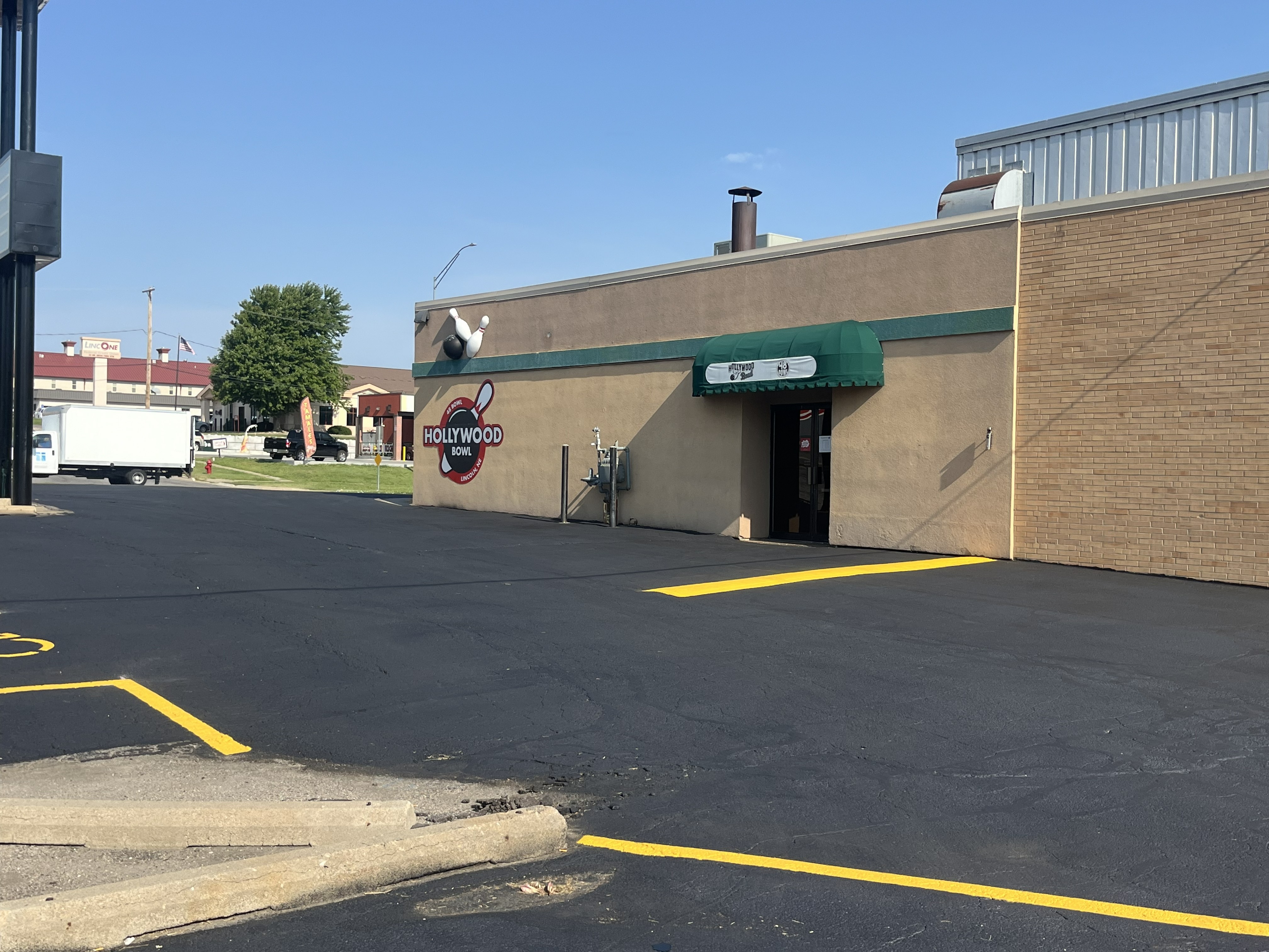 Sealcoated asphalt parking lot with fresh yellow striping at commercial property