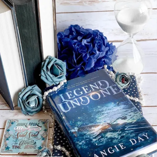 Legend Undone clean romantasy novel styled with blue flowers and fantasy aesthetic