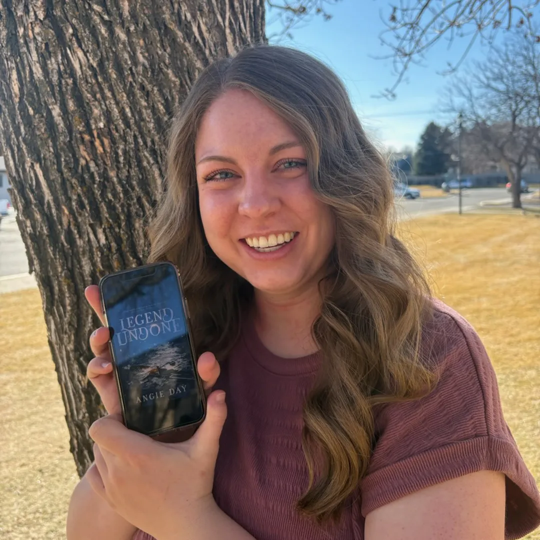 Happy reader holding Legend Undone fantasy romance ebook on tablet review photo