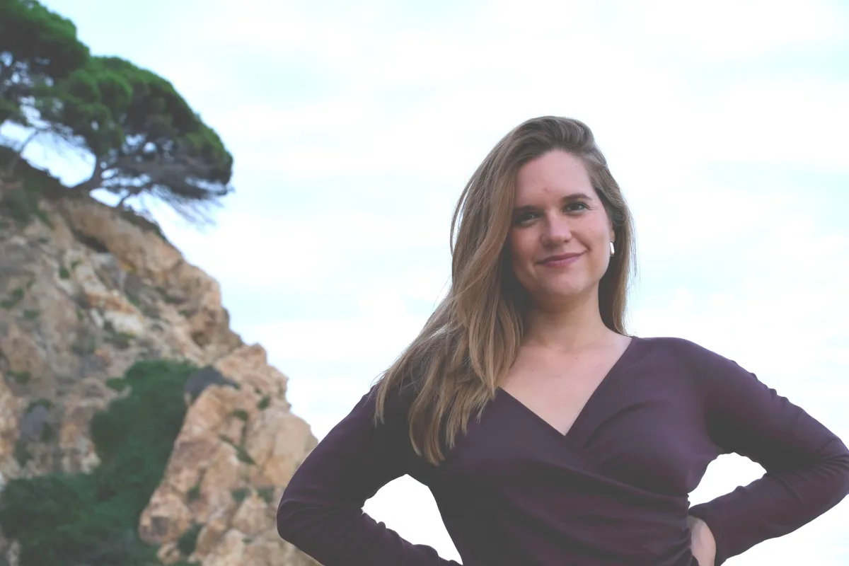Two women dancing freely in a sunny field, symbolising embodied ease in business.