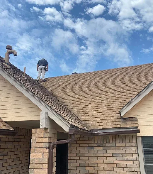 two men working on the roof of a house