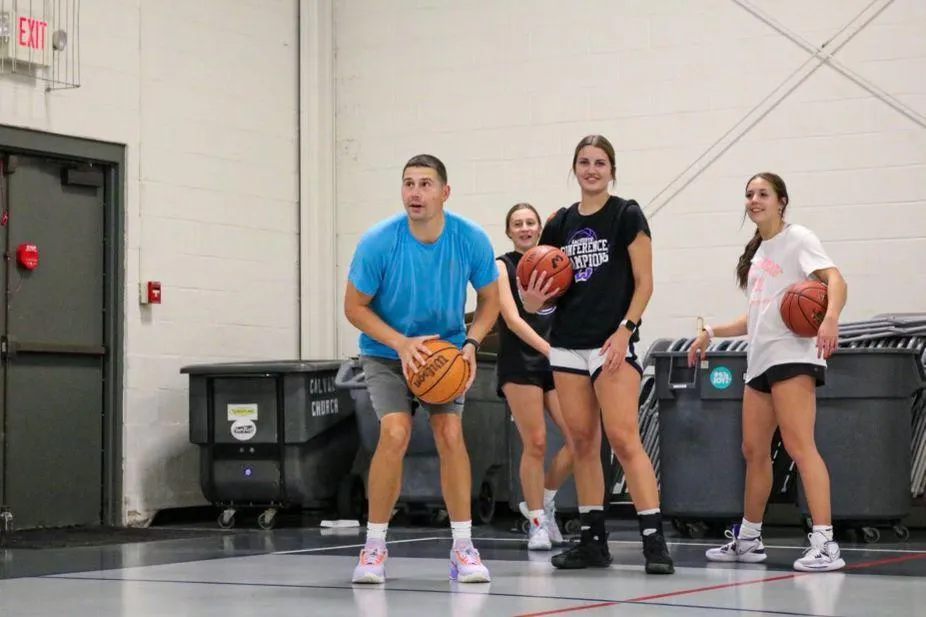 Basketball trainer Casey Teson leading a small group training session with athletes on the court