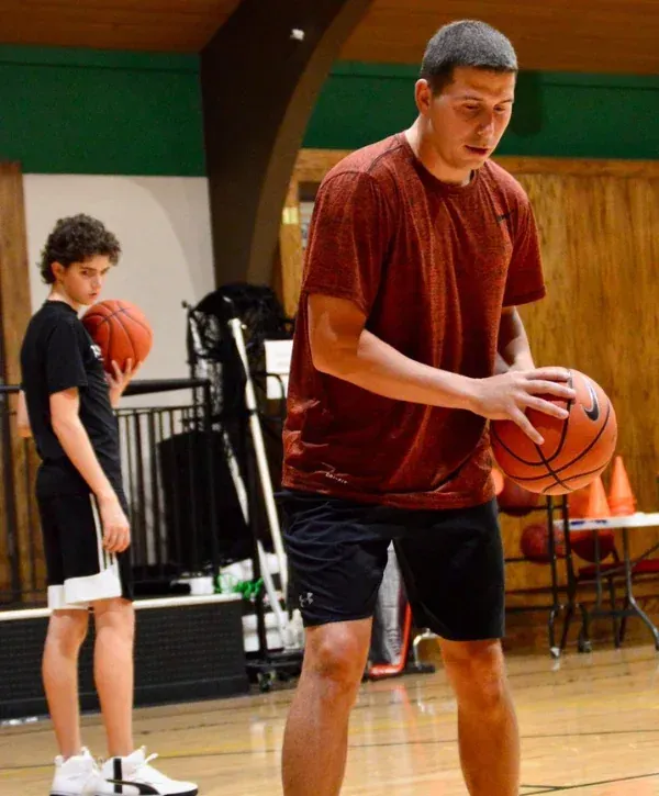 Youth basketball player practicing shooting form during indoor gym training