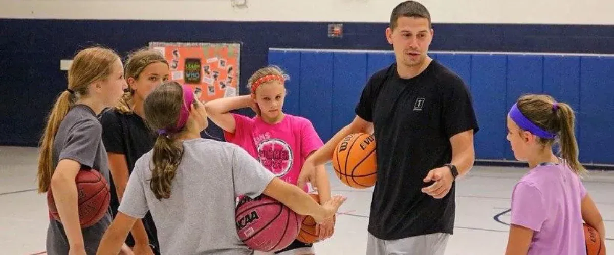 Basketball coach giving instructions to youth team during practice