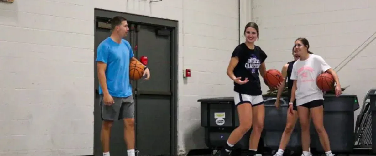 Basketball players moving between drills during practice session