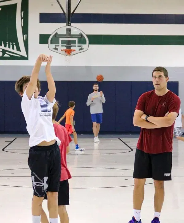 Youth basketball player practicing a jump shot during indoor training