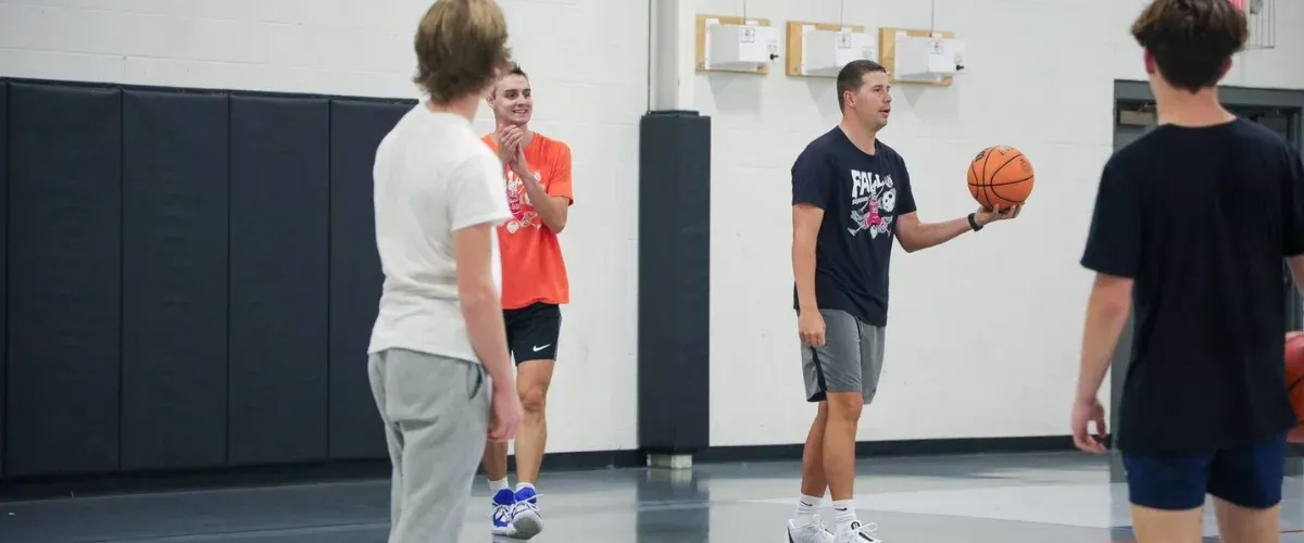 Coach teaching basketball fundamentals to girls during a youth training session.