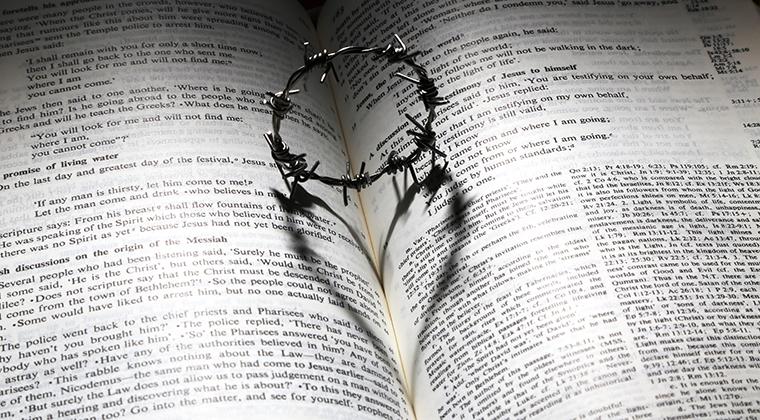 The Bible with crown of thorns casting a heart-shaped shadow