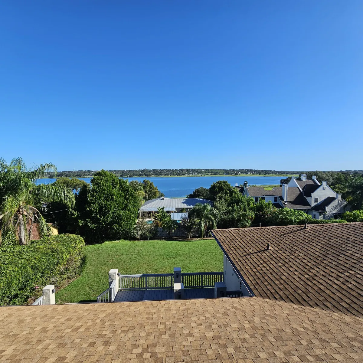Shingle roof in foreground with lake community view in Polk County, completed by American Roofing FL.
