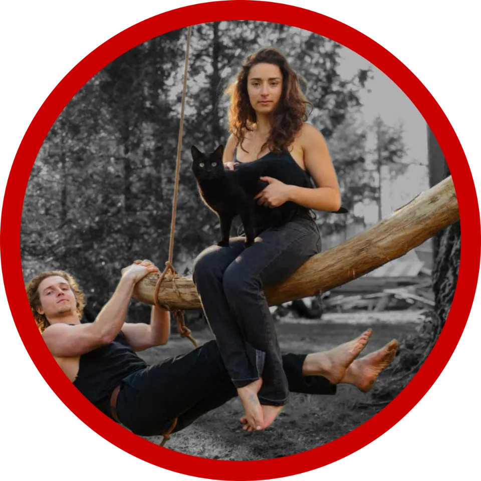 Woman sitting on swing with cat and man