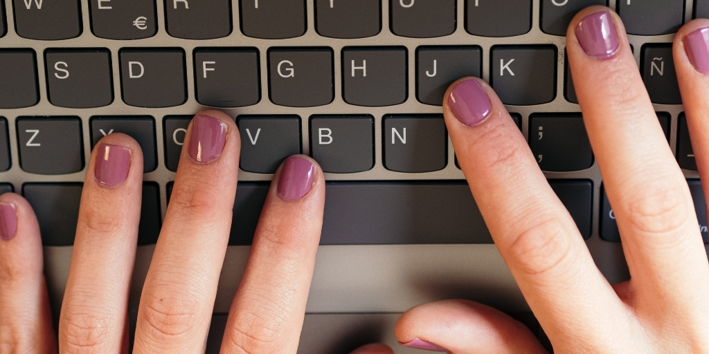 Close up of painted nails typing