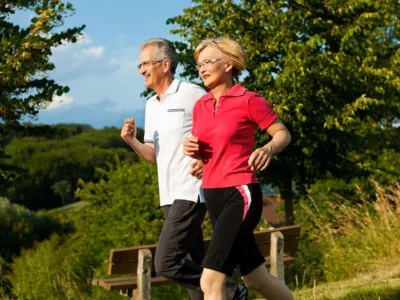 Active adults jogging outdoors in Cupertino promoting natural herbal medicine for pain relief, energy, and overall wellness support.