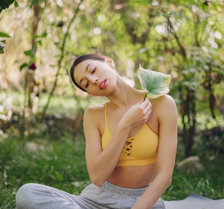 woman stretching her neck in nature, maintaining an active lifestyle thanks to the acupuncture clinic in cupertino ca.