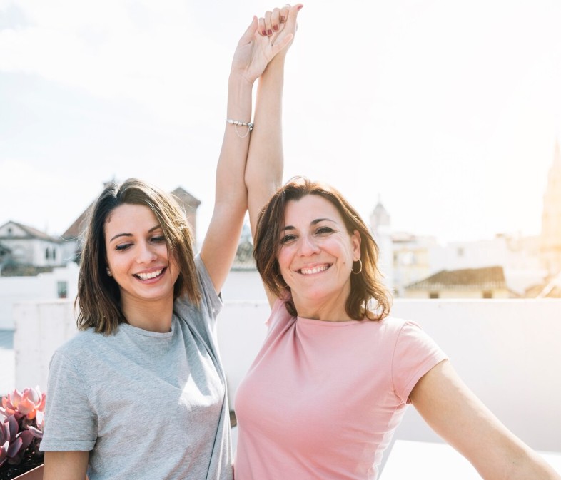 two women celebrating with raised hands, feeling the relief provided by the chronic pain acupuncture clinic in cupertino ca.