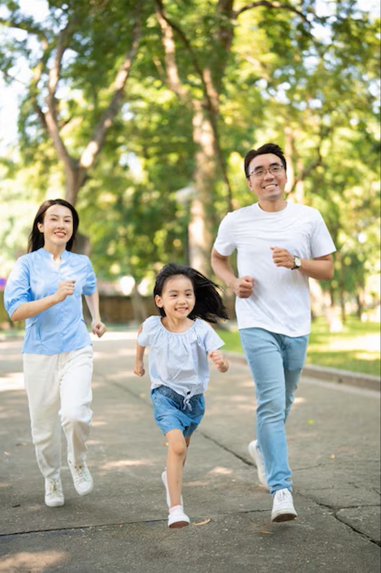 healthy, smiling asian family running together in a park, enjoying freedom from pain after effective pain control in cupertino ca.