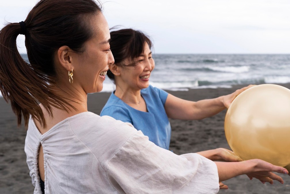 two happy women enjoying a day on the beach after getting treatment from a holistic medicine practitioner in cupertino ca.