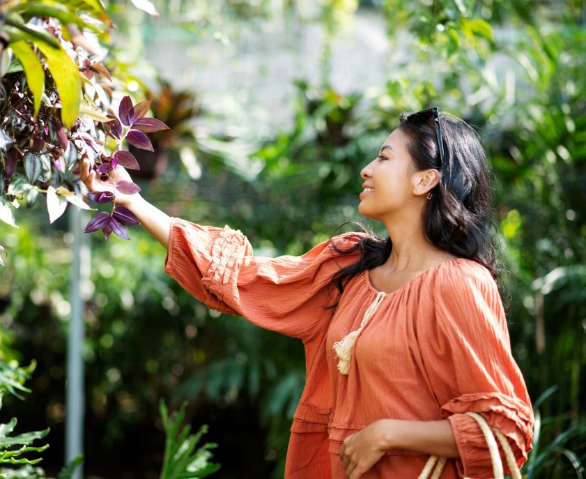happy woman smiling while walking through a garden after a session with a holistic medicine practitioner in cupertino ca.