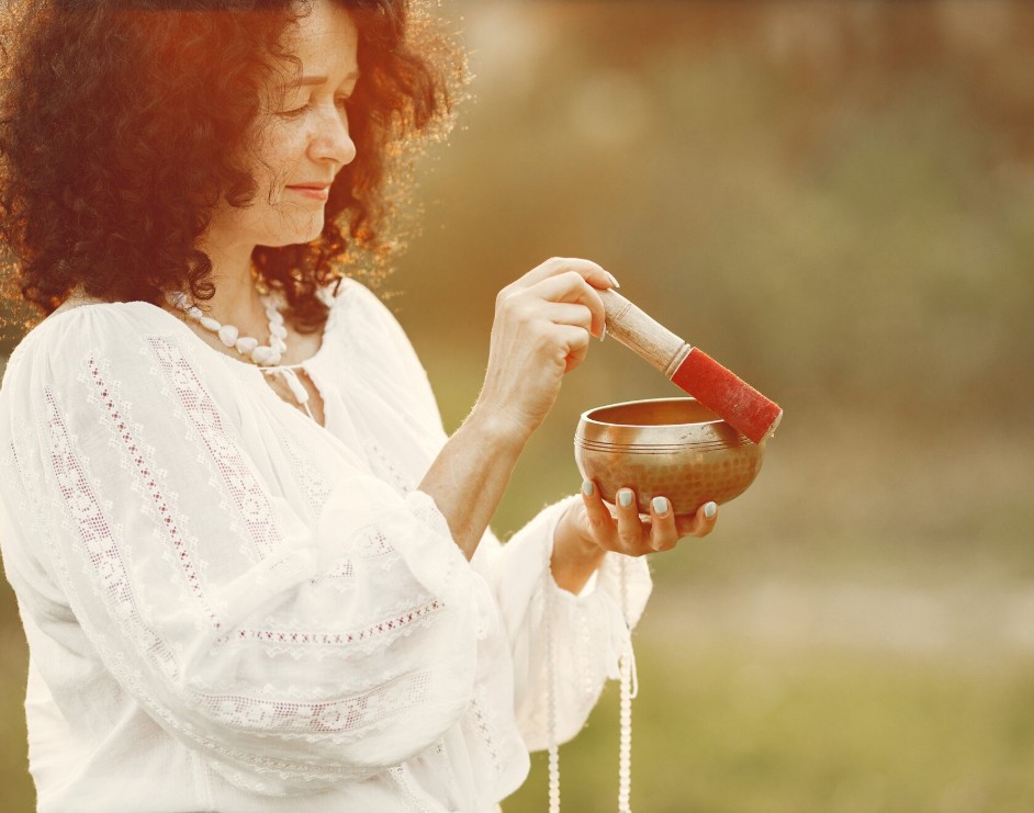 woman using a singing bowl for relaxation under the guidance of a herbal medicine practitioner in cupertino ca.