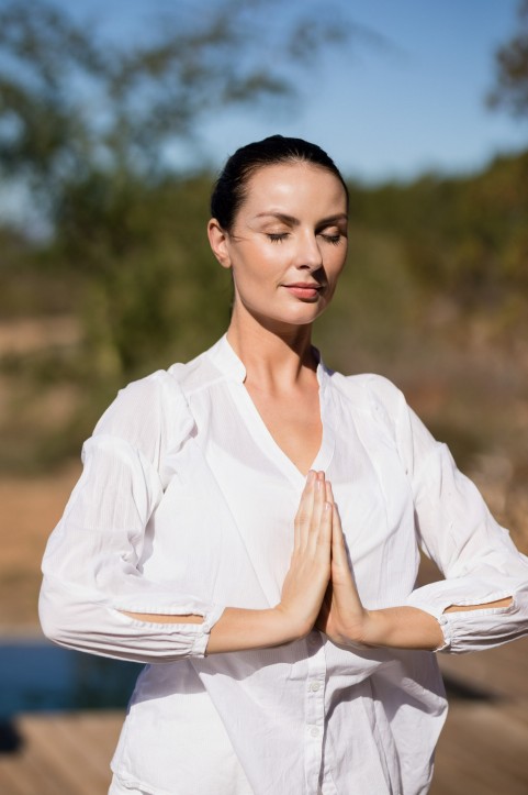 woman meditating outdoors with closed eyes after seeing an alternative medicine practitioner in cupertino ca.