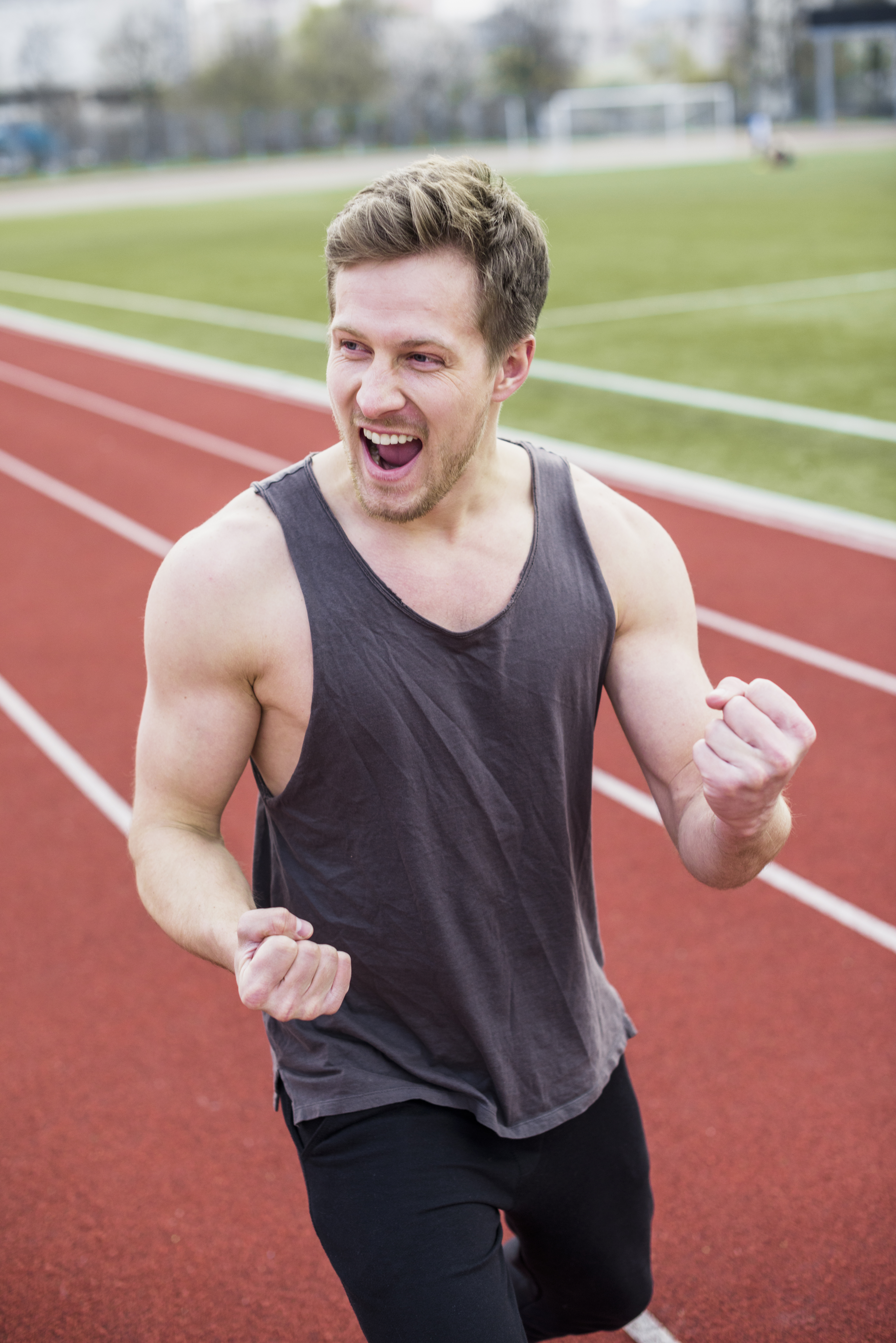 excited man celebrating his successful workout at a track stadium after getting care from a herbal medicine practitioner in cupertino ca.