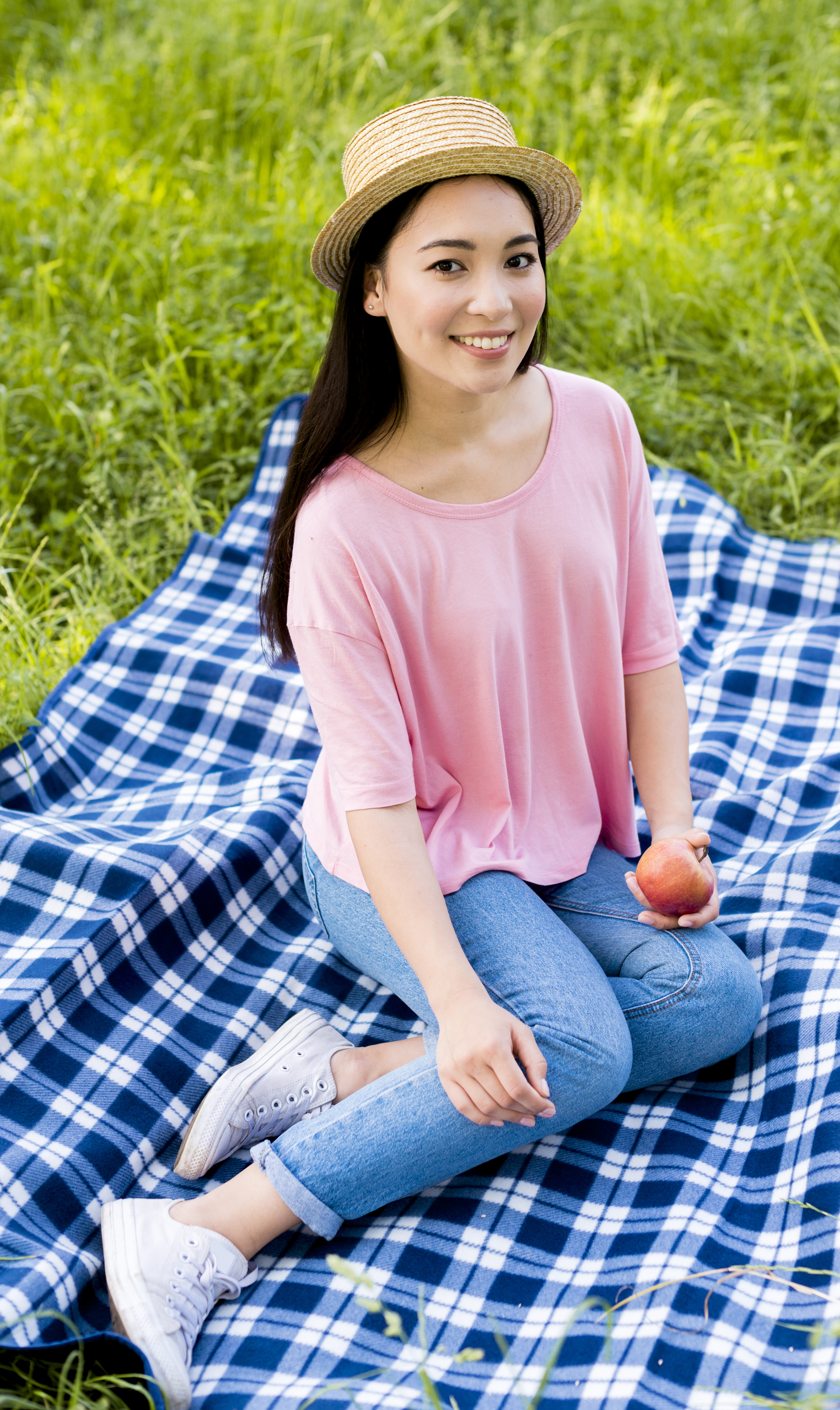 happy woman sitting on grass enjoying a healthy snack after a visit to an acupuncture clinic in cupertino ca.