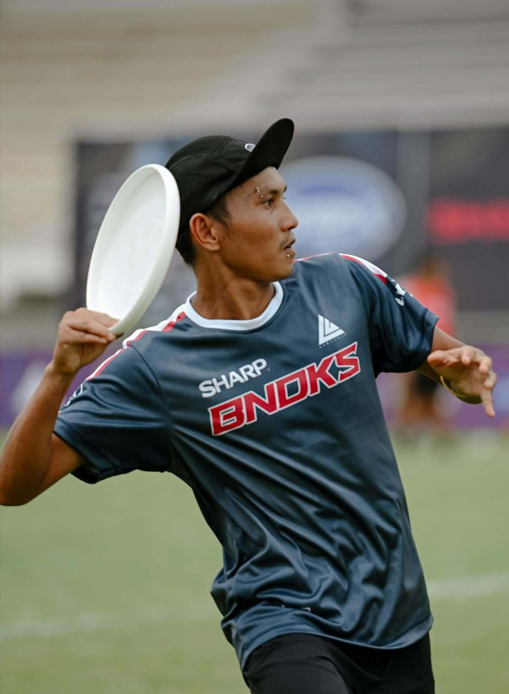 athletic man playing ultimate frisbee during a competitive tournament on a grassy field from acupuncture clinic in cupertino ca.