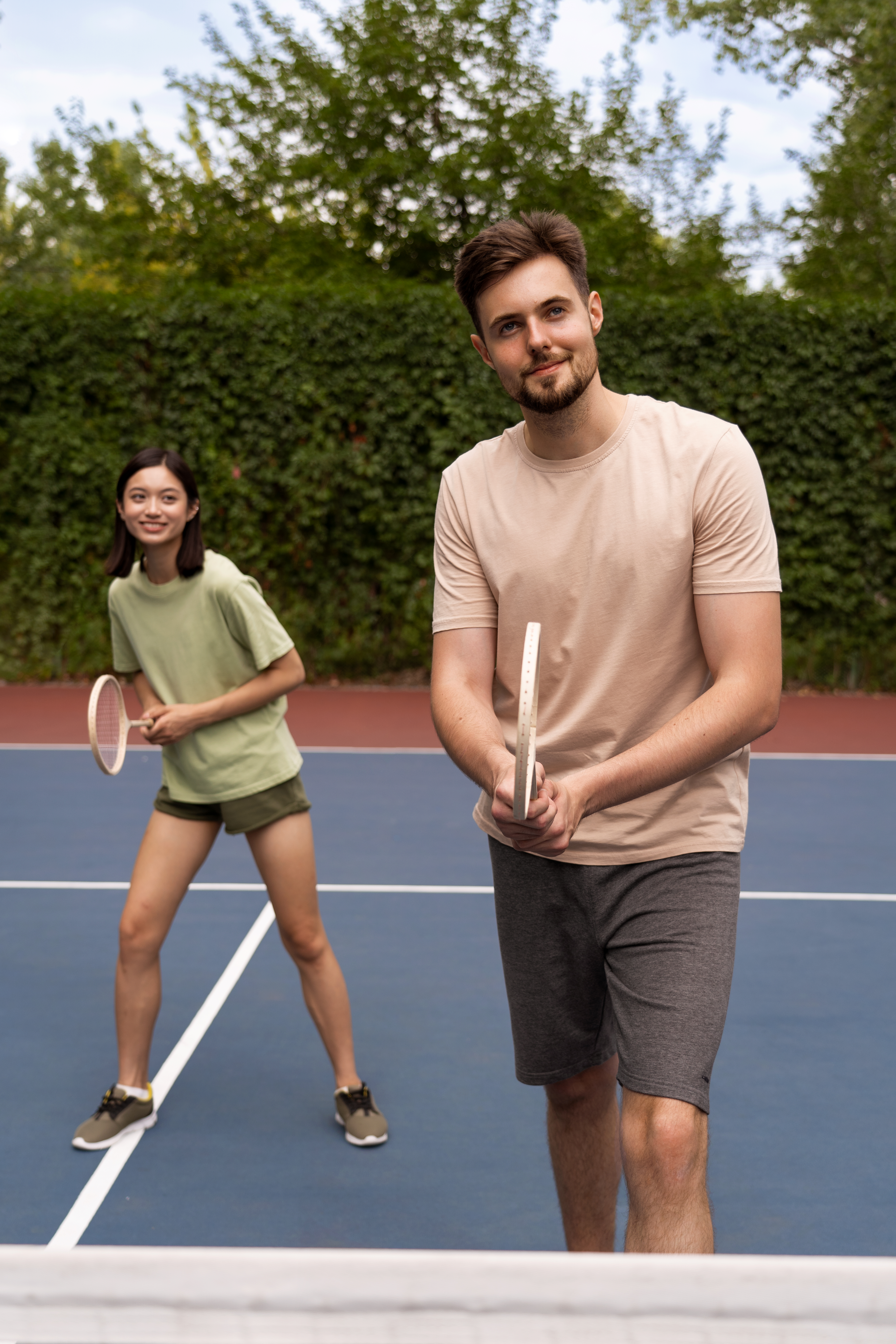 young man and woman playing badminton on a court after care at a pain-relief acupuncture clinic in cupertino ca.