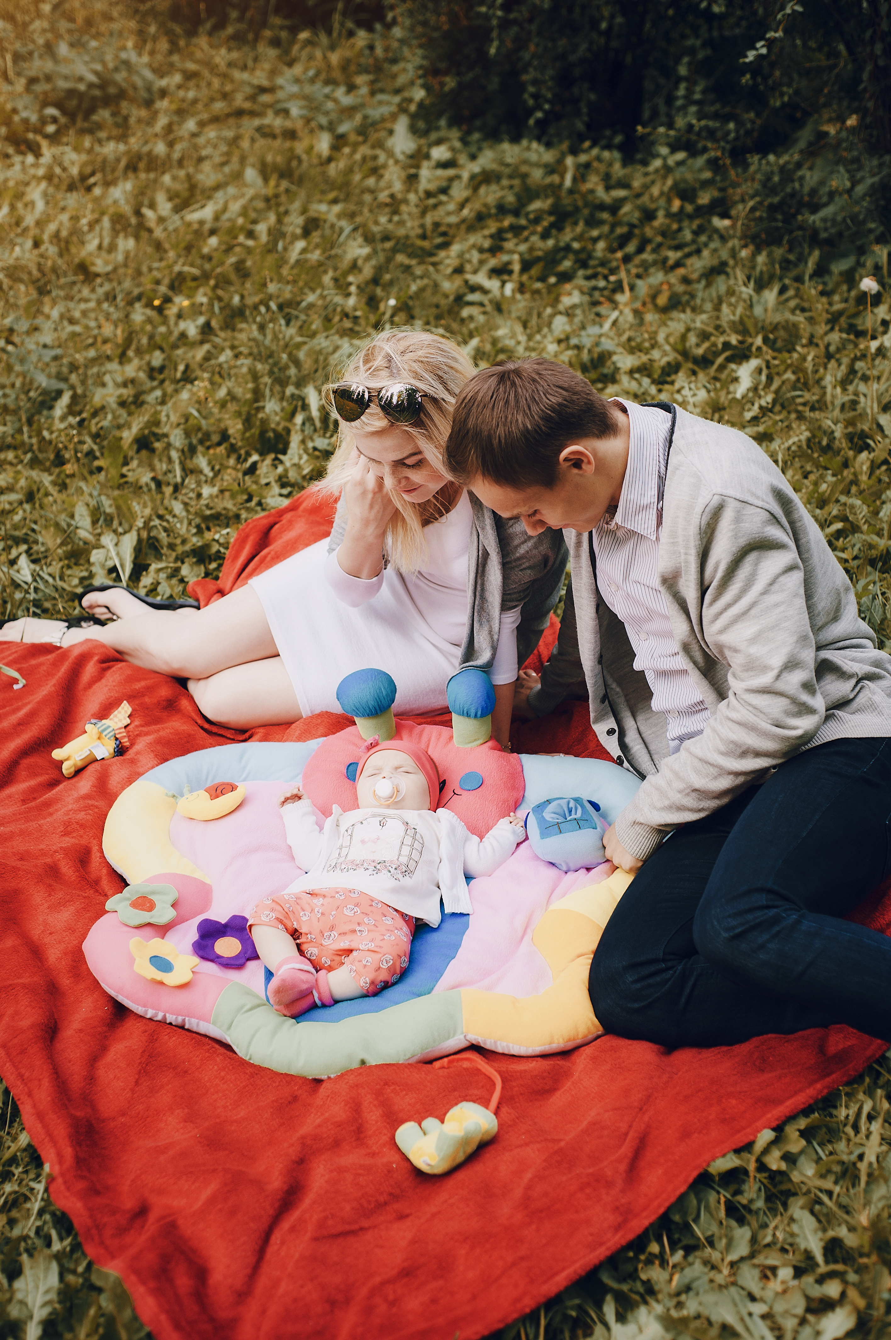 loving parents watching their newborn sleep on a blanket after help from a fertility clinic in cupertino ca.