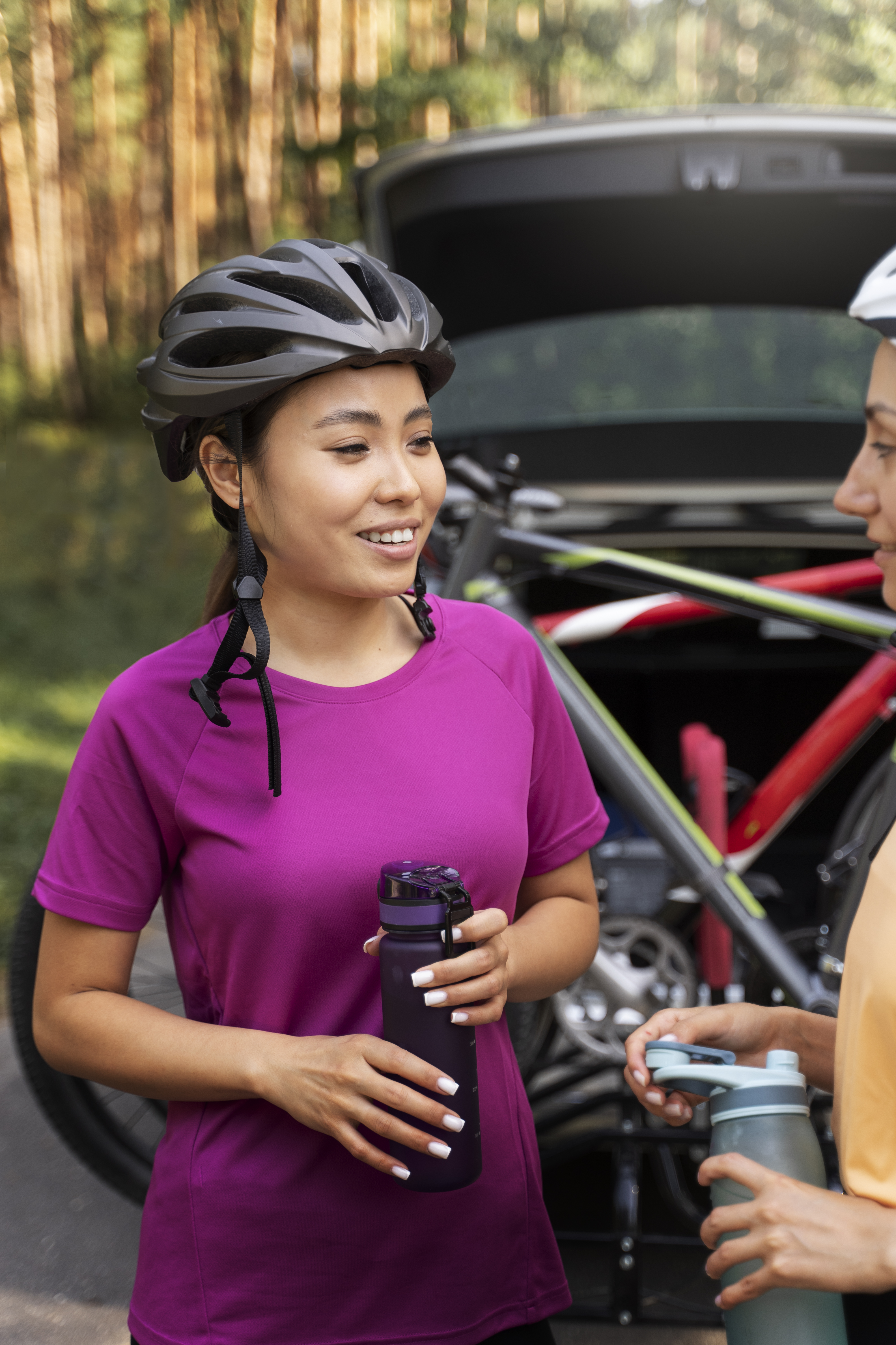happy woman with bike helmet holding water bottle after visiting an acupuncture clinic in cupertino ca.