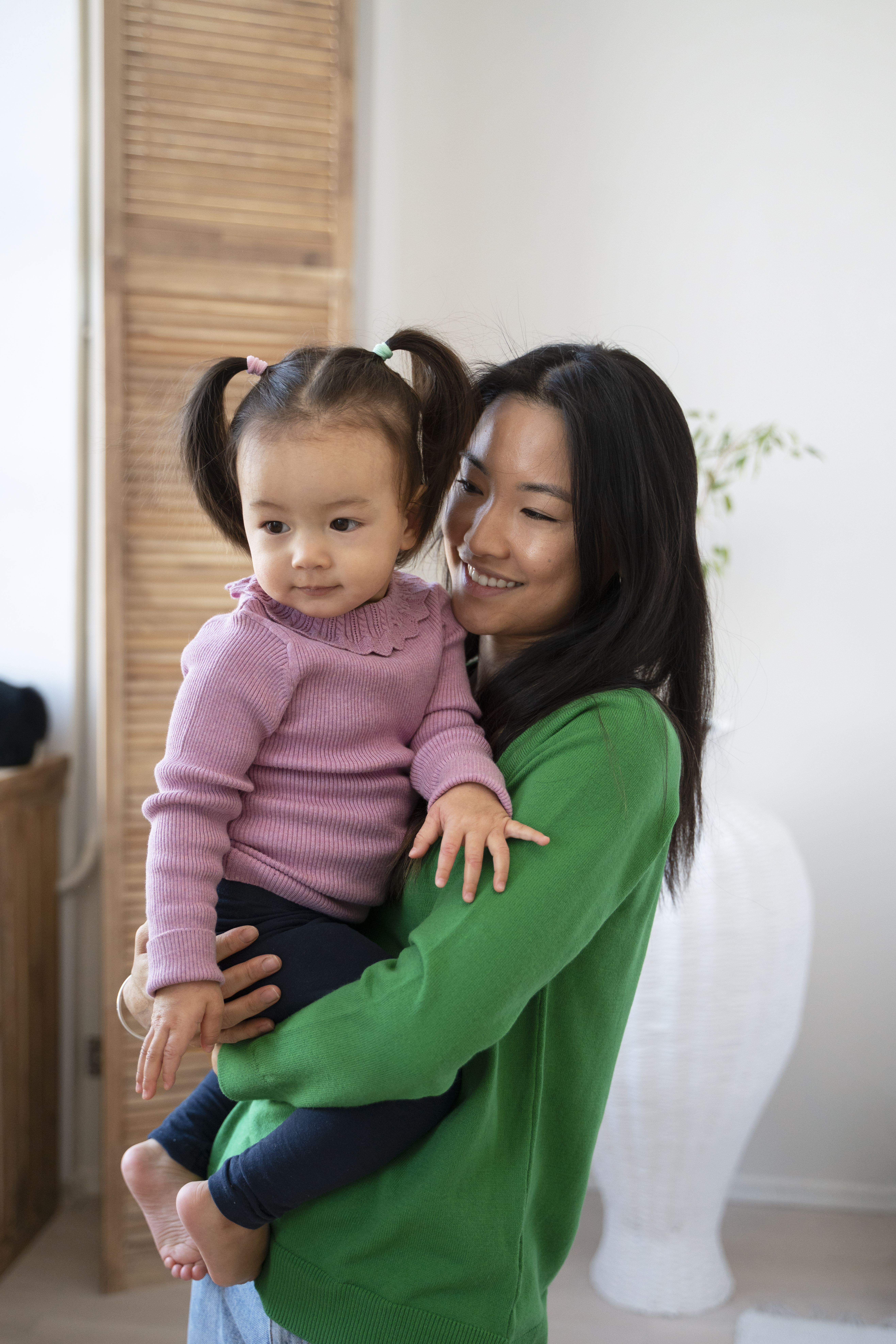 smiling woman holding her toddler at home thanks to support from an ivf acupuncture clinic in cupertino ca.