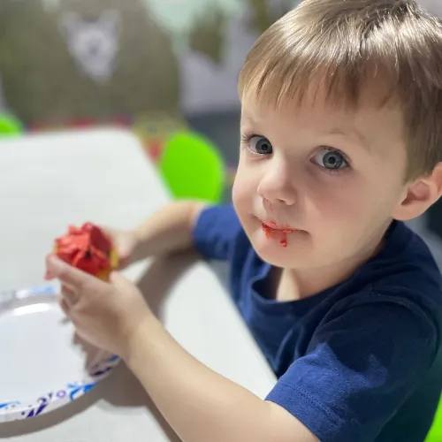 Boy picks paper out of different colored liquids