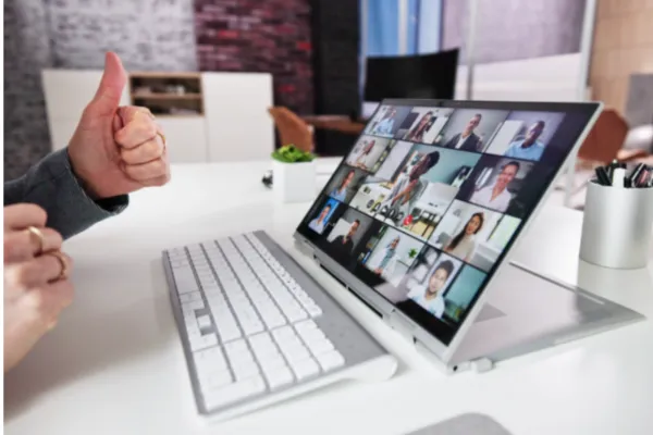 A person, serving as a marketing virtual assistant, utilizes a laptop for a video conference, demonstrating virtual collaboration.