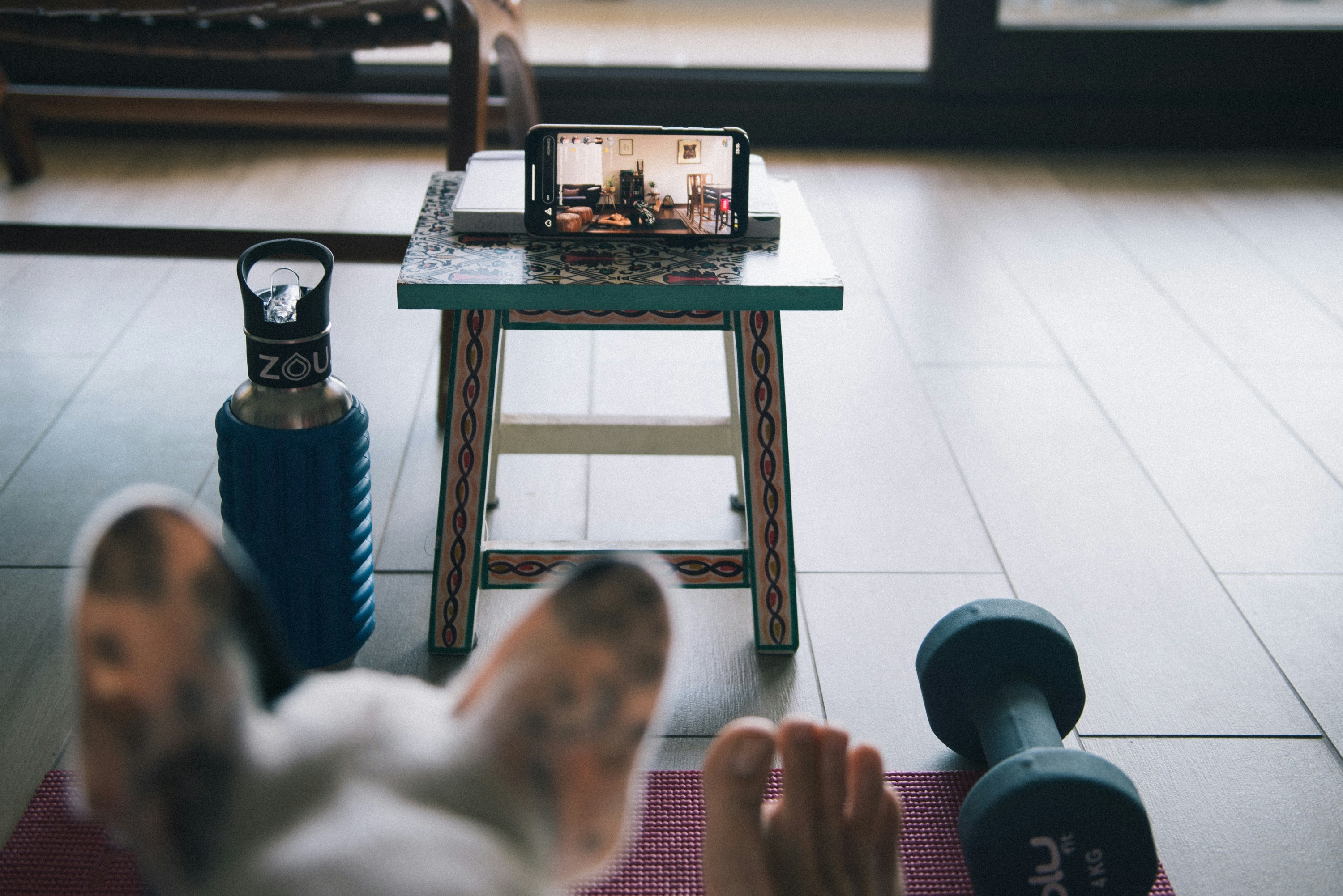 Person doing an at-home online workout following a coach on a phone or laptop