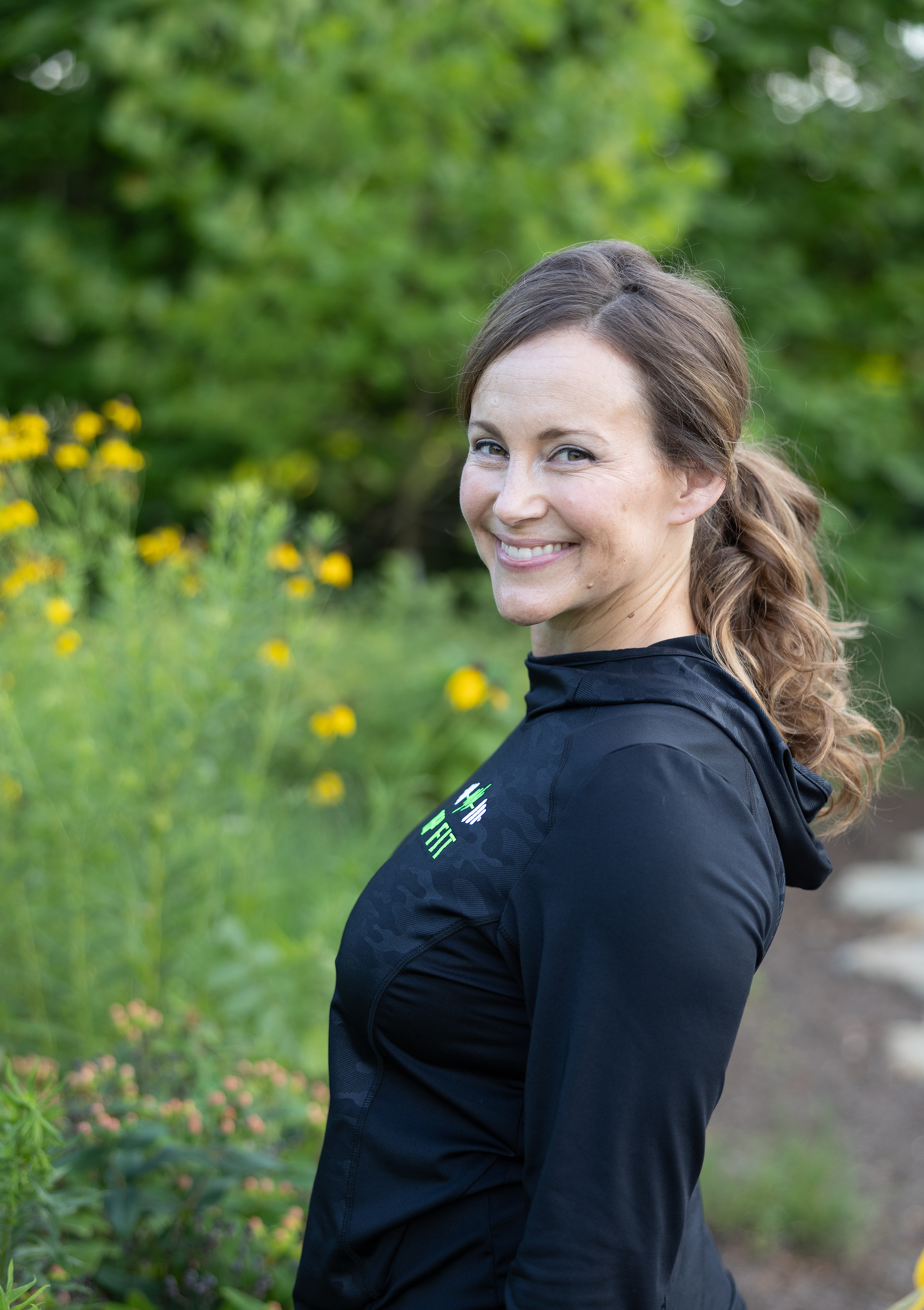Coach Steph smiling outdoors in fitness gear