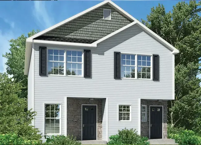 A two-story, semi-detached house with a stone and siding exterior, black shutters, and two front doors, nestled among trees—a charming example of J Houston Park Homes.