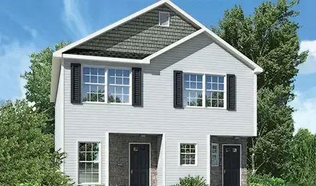 A modular duplex in Houston featuring a gray exterior, black shutters, and two front doors under a gabled roof. Trees enhance the backdrop.