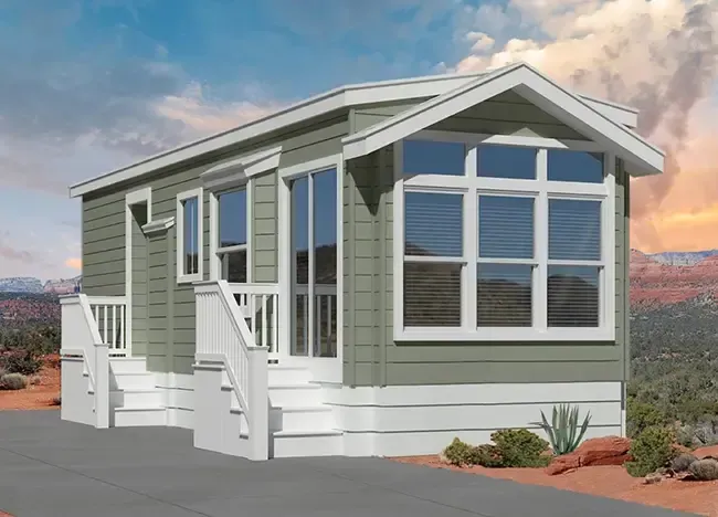 A small green house with a white trim, multiple windows, and two sets of steps leading to separate entrances. The background shows a desert landscape with a cloudy sky.