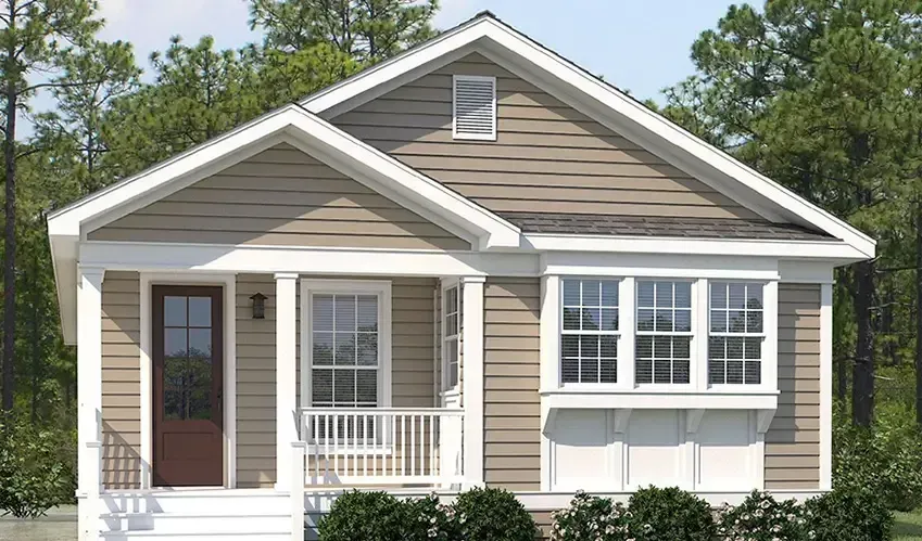 A modular duplex in Houston featuring a gray exterior, black shutters, and two front doors under a gabled roof. Trees enhance the backdrop.