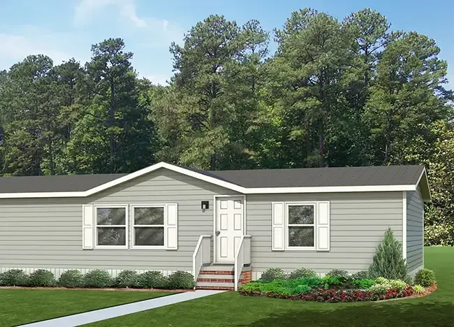 A single-story, gray house with white trim, surrounded by a manicured lawn, shrubs, and trees in the background. Offered by J Houston Properties, the house features a front door with a small set of stairs leading up to it.