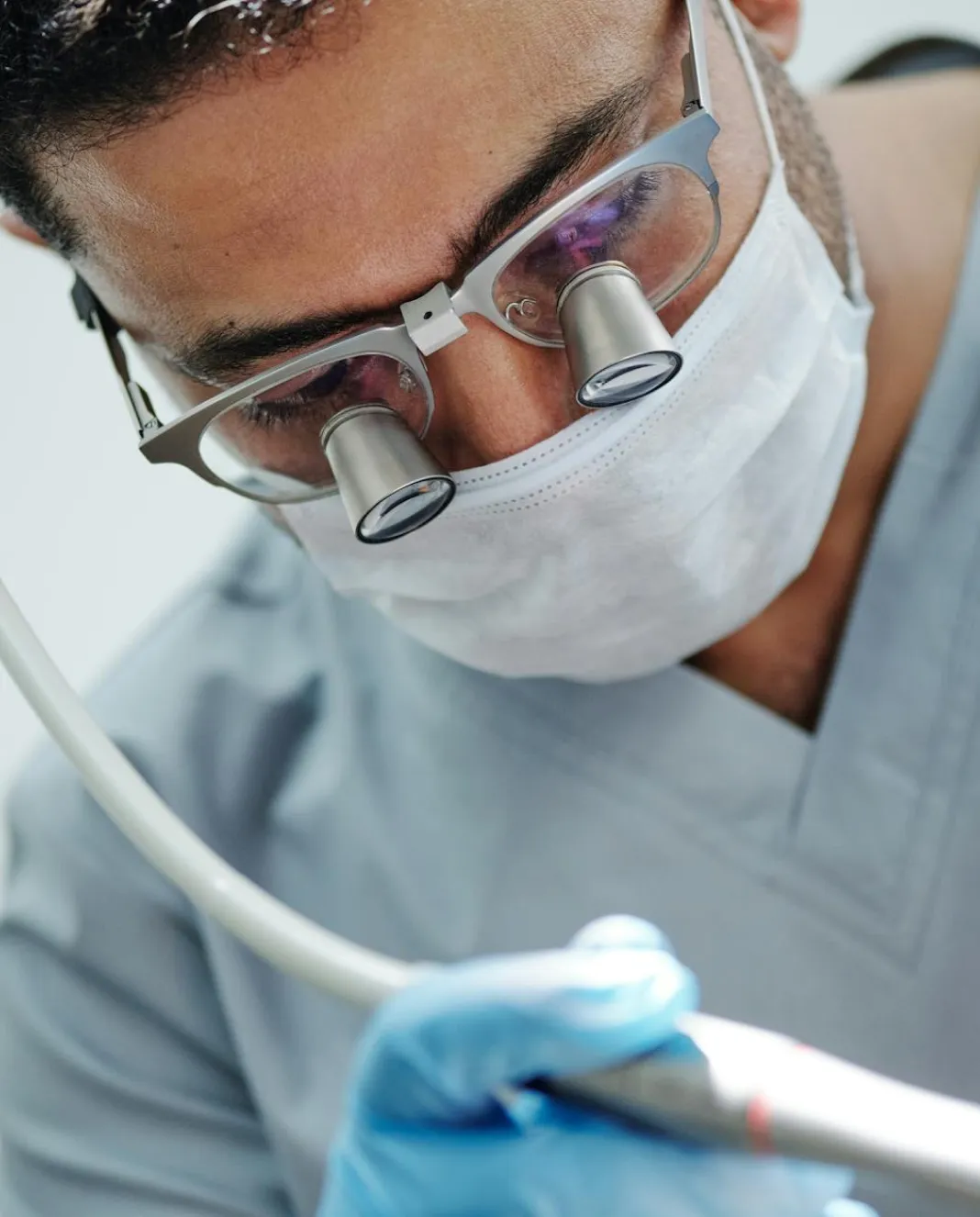 Close-up of a dentist wearing protective equipment while performing a precise dental treatment.