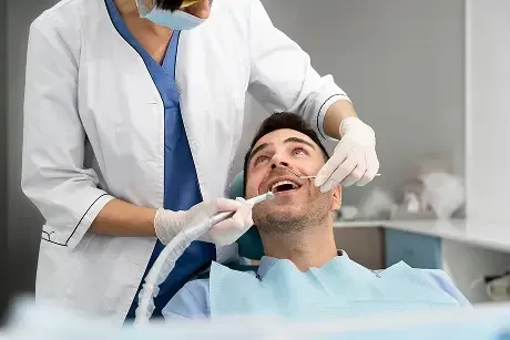 Patient receiving a professional dental examination and treatment while seated comfortably in a modern dental clinic.
