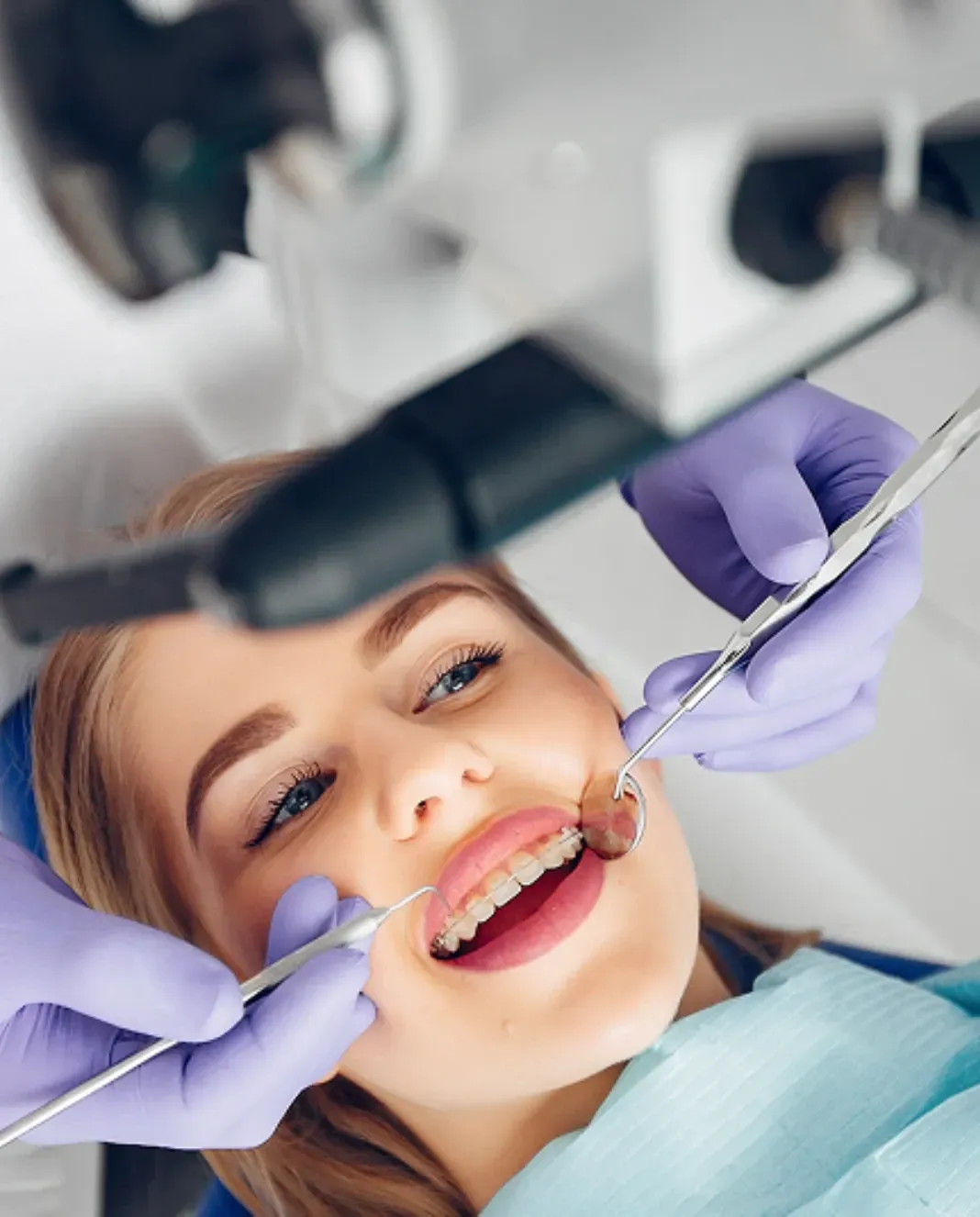 Patient receiving a professional dental examination while a dentist uses dental instruments to assess her teeth.
